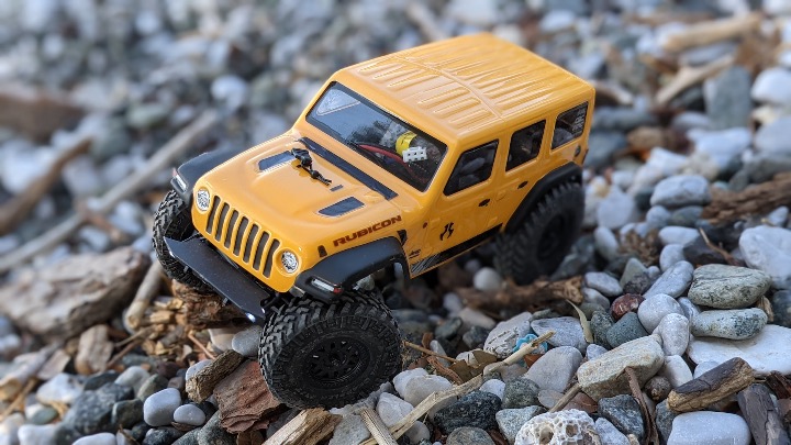 Axial SCX24 Jeep Wrangler yellow and black jeep wrangler scale model RC on the rocks